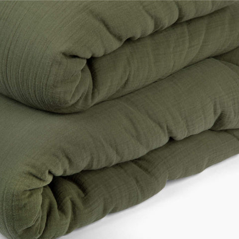 A detailed view of the fabric on the Avec lightweight cotton quilt in moss
