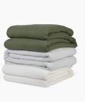 Avec cotton quilts in various colors stacked neatly on a white background