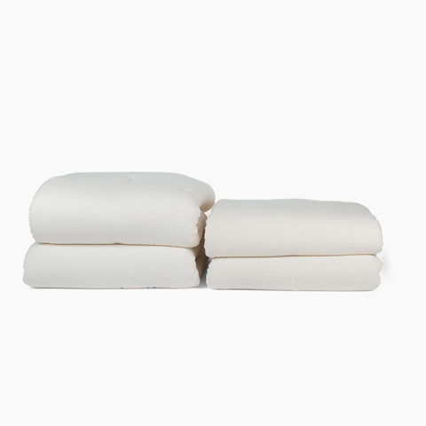 Avec all-season and lightweight cotton quilts in pearl folded neatly on a white background