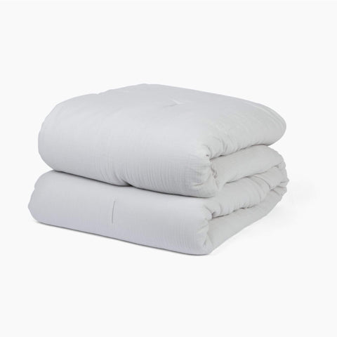 Avec cotton quilt in mist folded neatly on a white background