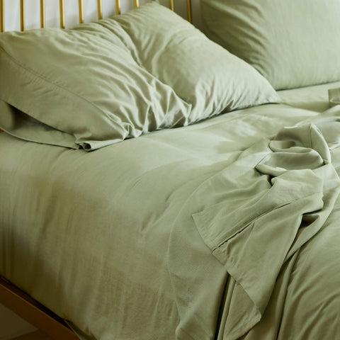 A morning view of a bed made with Avec bedding linen-blend sheets