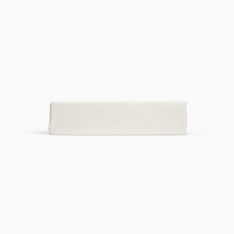 Avec linen fitted sheet in bone folded neatly on a white background